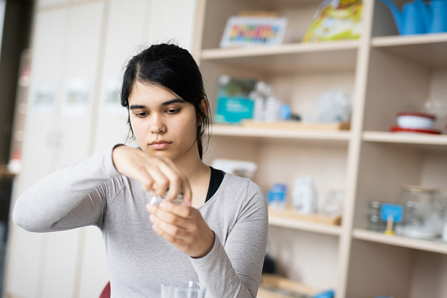 Eine Erzieherin beschäftigt sich in der Lernwerkstatt mit früher naturwissenschaftlicher Bildung.