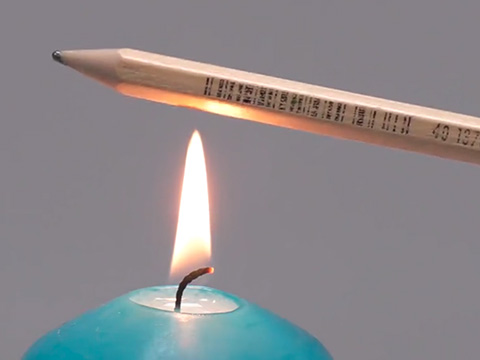 Eine Bleistift über einer Kerzenflamme.