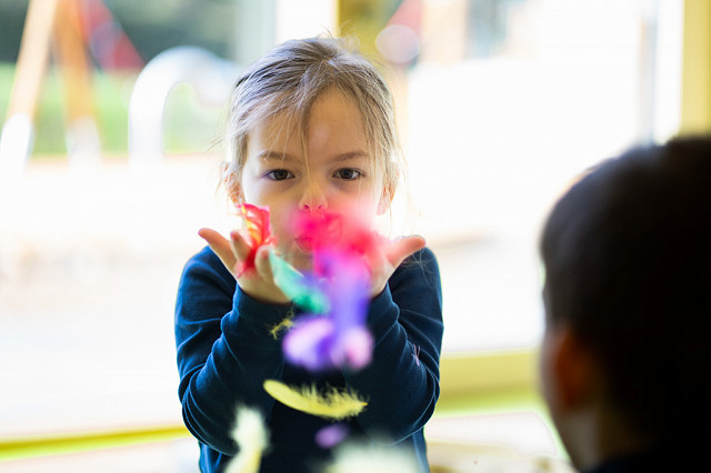 Ein Kita-Kind untersucht Blätter und Rinde. Kinder haben ein natürliches Interesse an Natur-Phänomenen.